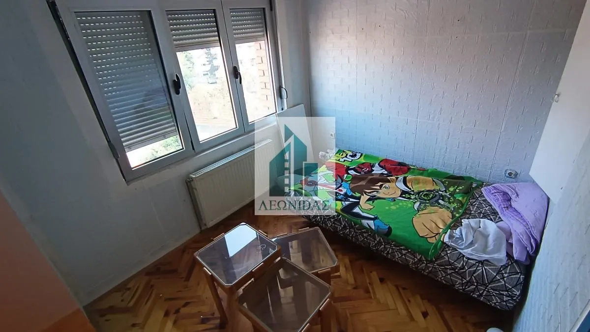 Manja spavaća soba sa krevetom i prozorom.