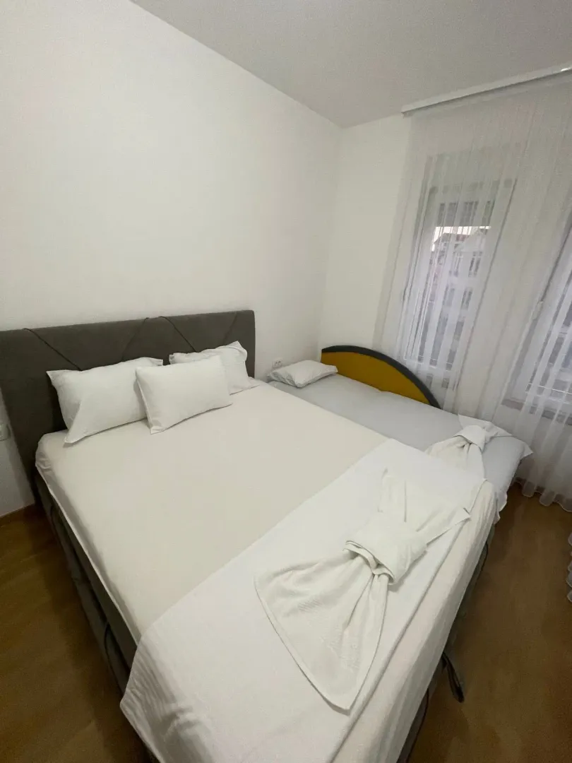 Spavaća soba sa bračnim krevetom i dodatnim krevetom.