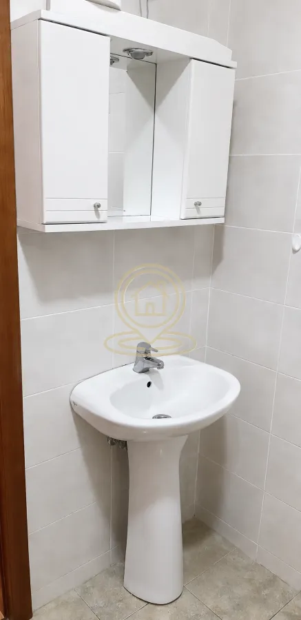 Kupatilo sa umivaonikom i ormarićem sa ogledalom.