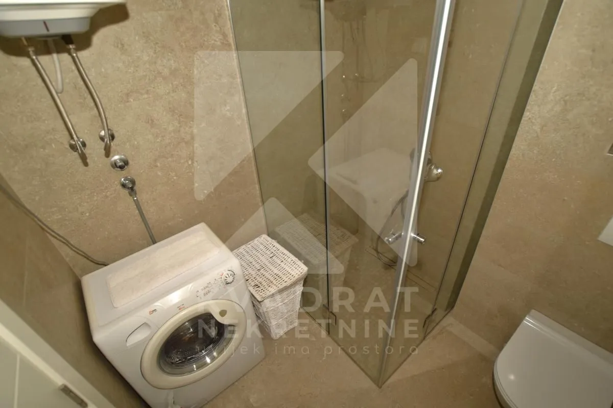 Bathroom with a shower cabin and a washing machine.
