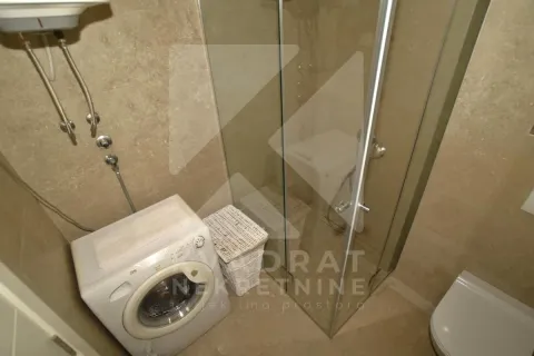 Bathroom with a shower cabin and a washing machine. - image 6