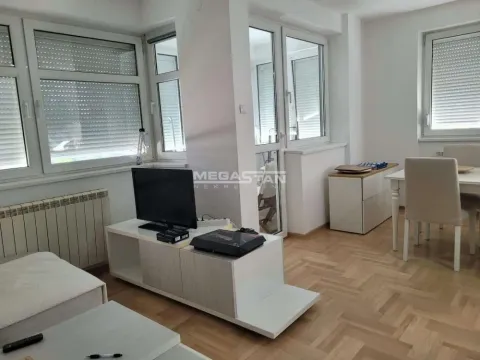Dnevna soba sa garniturom, televizorom i trpezarijskim stolom pored prozora. - image 3