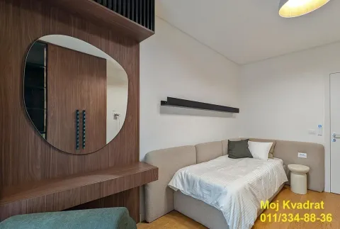 Smaller bedroom with a bed and a wooden wall panel with a mirror. - image 10