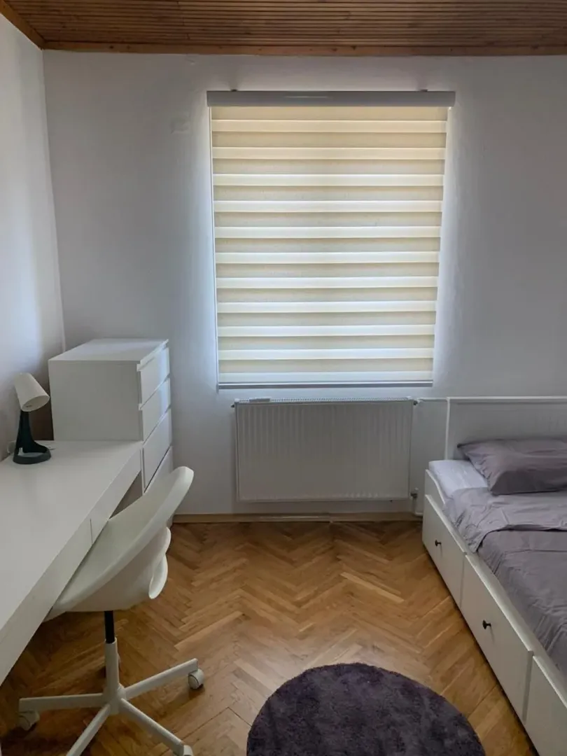 Bright bedroom with a desk and a bed.