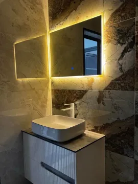 Modern bathroom with a sink and backlit mirror. - image 19
