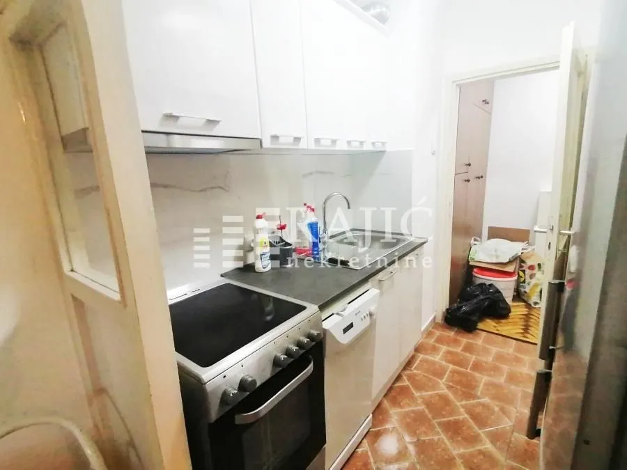 Small kitchen with white cabinets and a stove.
