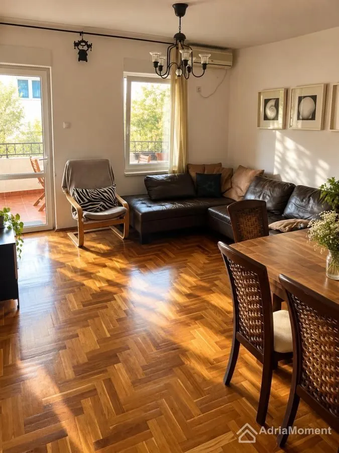 Living room with a sofa set, wooden floor, and dining table.
