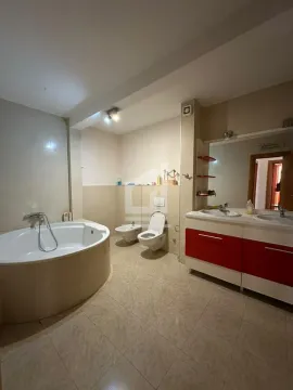 Spacious bathroom with a corner bathtub, double vanity, and sanitary ware. - image 6