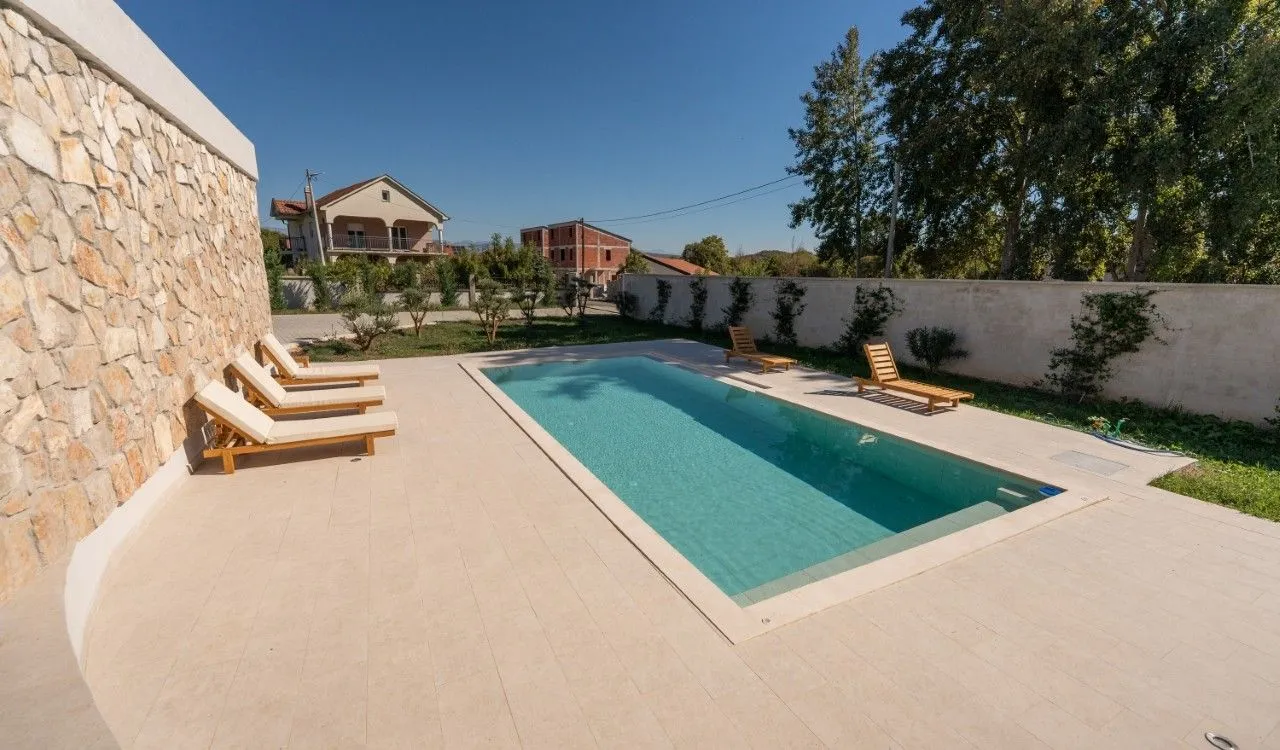 Swimming pool in the yard with sun loungers.