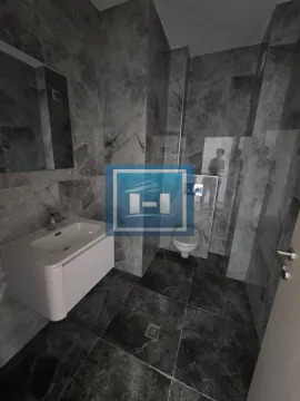 Moderno kupatilo obloženo sivo-crnim mermernim pločicama sa umivaonikom i toaletom. - image 6