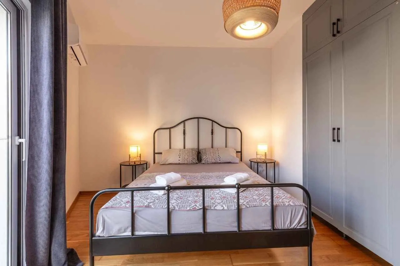 Furnished bedroom with a double bed, bedside tables, and a large built-in wardrobe.