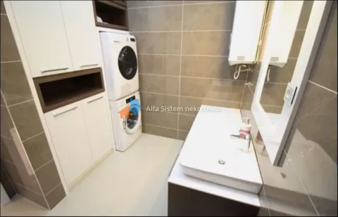 Bathroom with a sink, mirror, and a built-in washer and dryer. - image 20