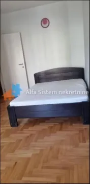 Spavaća soba sa bračnim krevetom i parketom na podu. - image 6