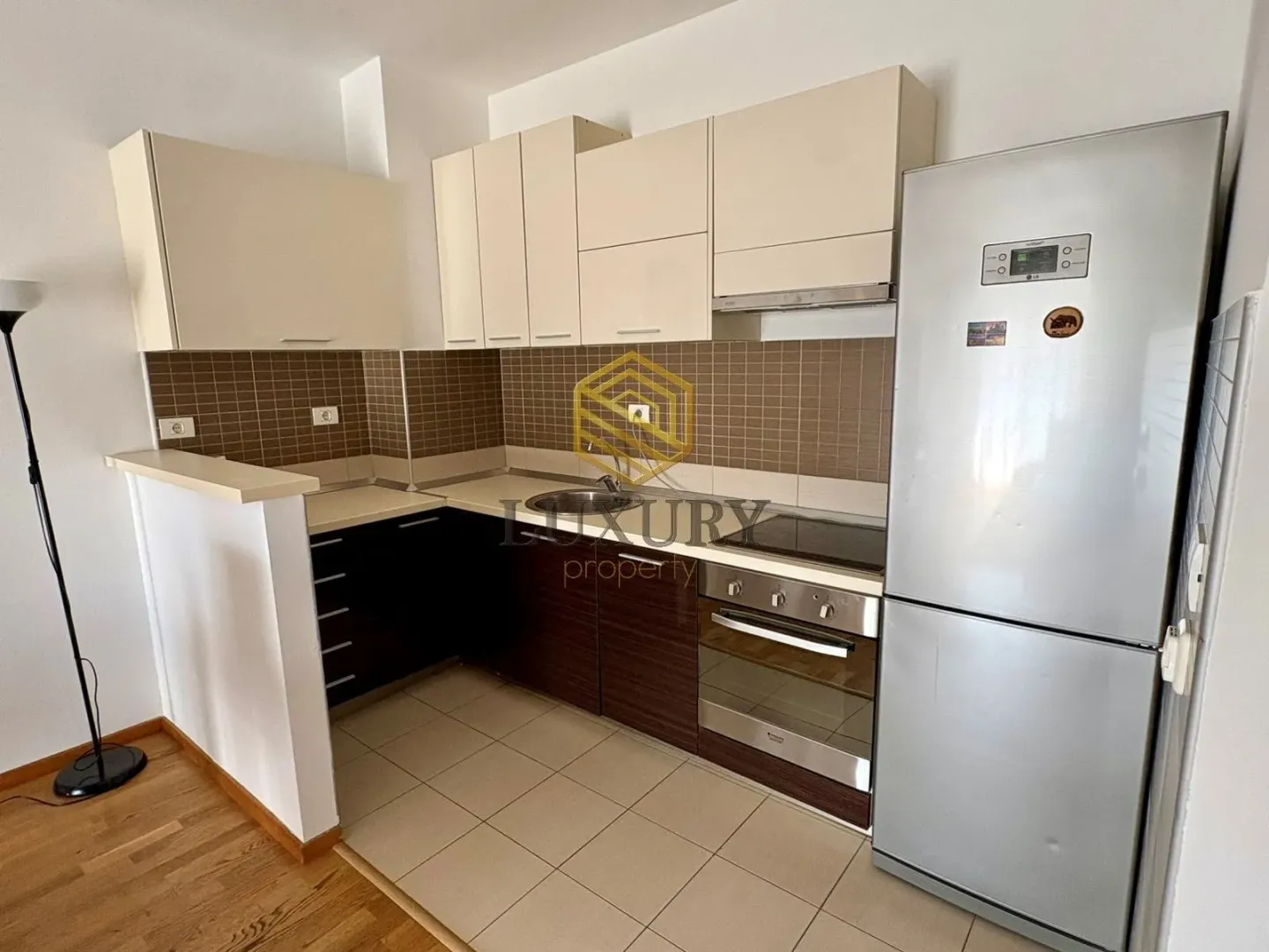 Small kitchen with upper and lower cabinets and built-in appliances.