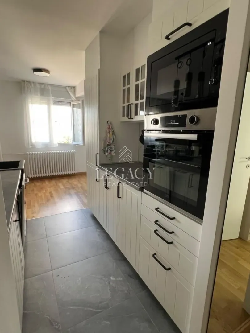 White kitchen with built-in oven and microwave.
