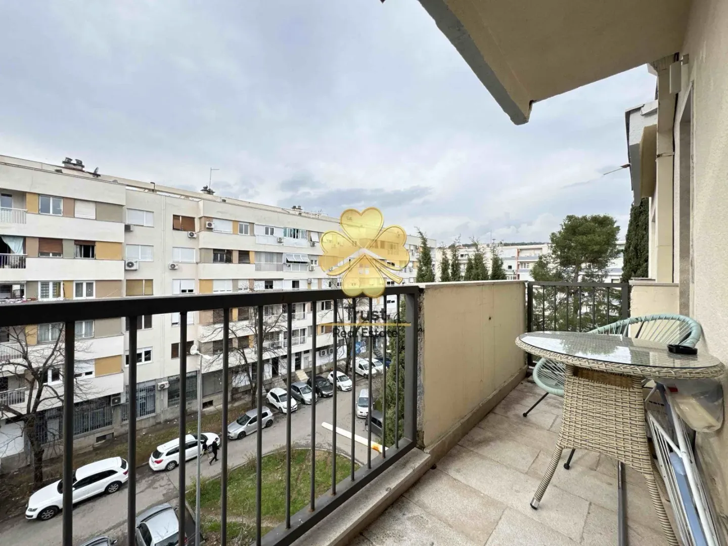 Covered balcony with seating furniture and a view of the neighborhood.