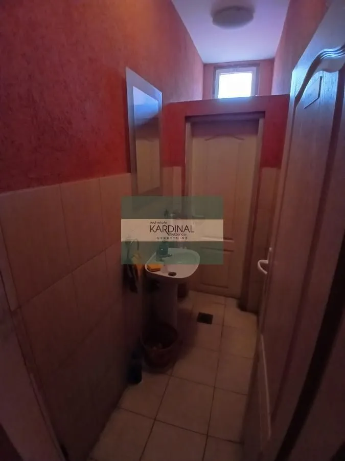 Small bathroom with a sink and tiled walls.