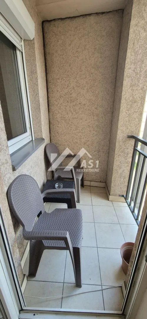 Manji natkriveni balkon sa garniturom za sedenje.