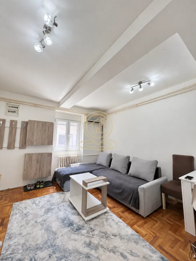 Living room with a sectional sofa, coffee table, and parquet flooring.