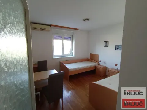 Bedroom with two beds and a dining table. - image 8