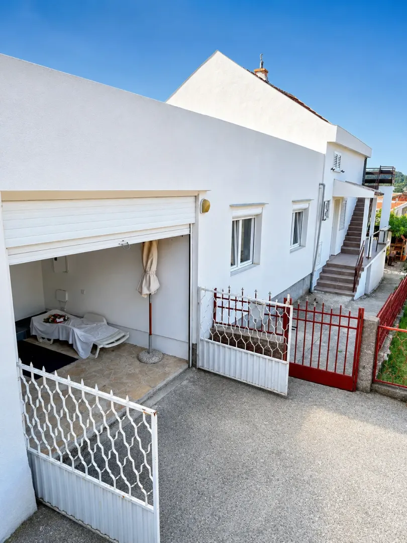 Exterior of the house with yard, fence, and garage.
