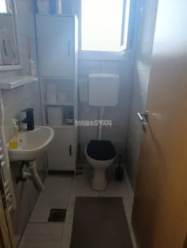 Small bathroom with a sink, toilet, and white cabinet. - image 6