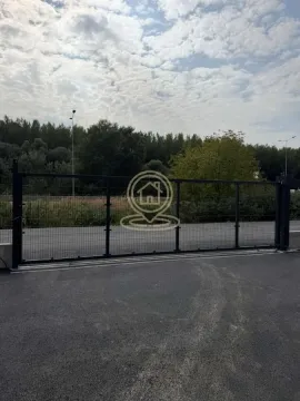 Black metal fence and yard gate with paved driveway. - image 2