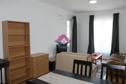 Living room with sofa, dining table, and shelving units. - image 18