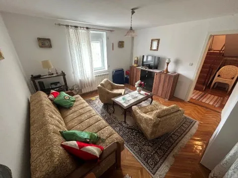 Living room with a sofa, armchairs, and a television. - image 9