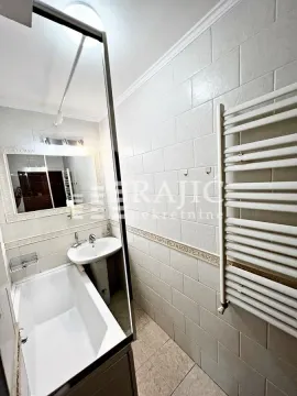 Smaller bathroom with a bathtub, washbasin, and towel radiator. - image 18