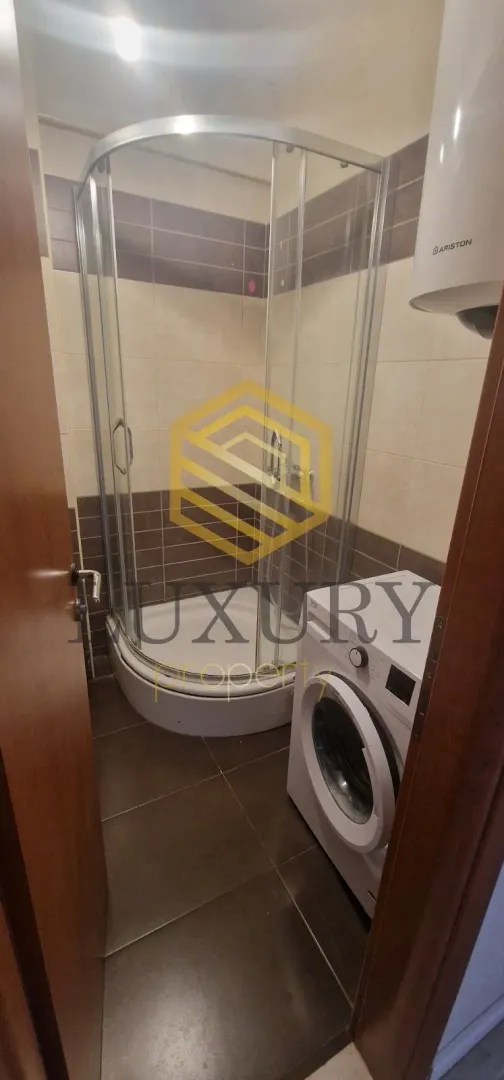 Small bathroom with a shower cabin and a washing machine.