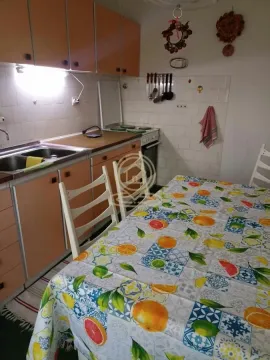Starija kuhinja sa trpezarijskim stolom i narandžastim elementima. - image 4