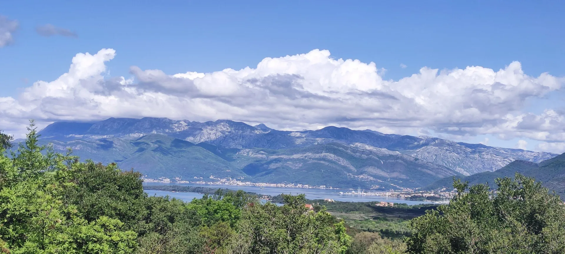 Panoramski pogled na more, obalu i planine u daljini.