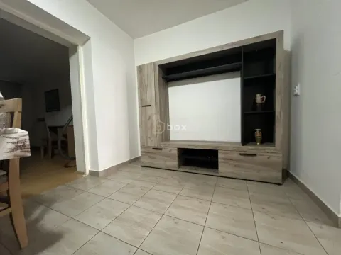 Dnevna soba sa velikom drvenom komodom i keramičkim pločicama na podu. - image 8