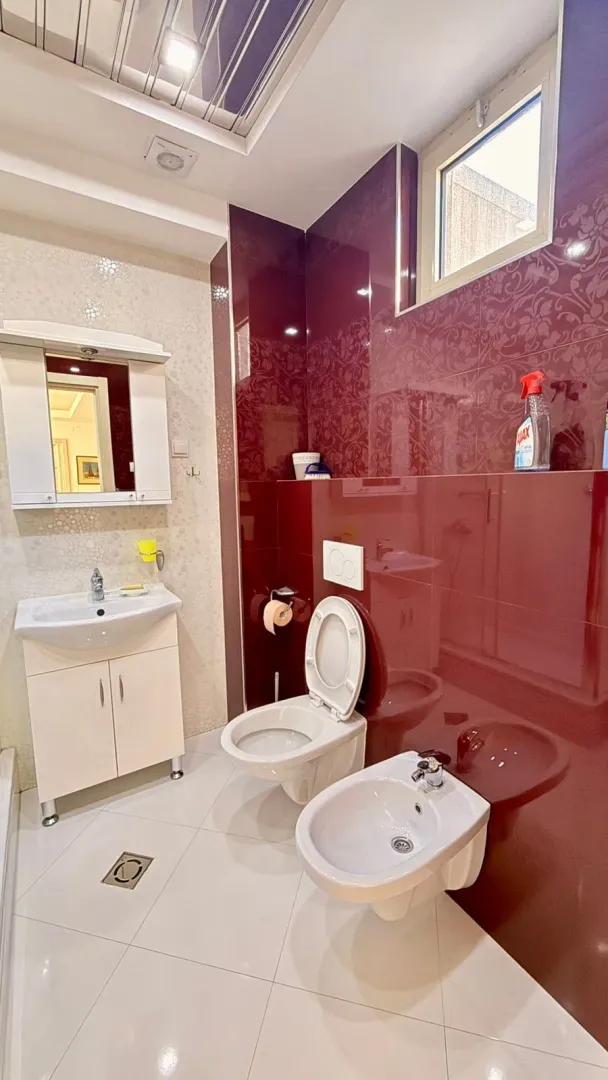 Modern bathroom with sink, toilet, and bidet.