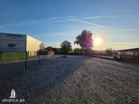 Pogled na ograđeni plac sa šljunkovitom podlogom i okolnim objektima. - image 4