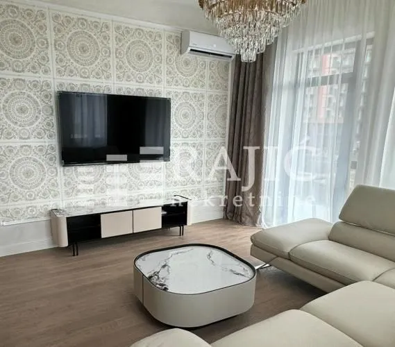 Modern living room with a sofa, TV, and coffee table.