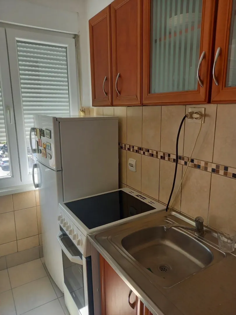 A small functional kitchen with a refrigerator, stove, and sink.