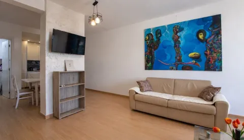 Dnevna soba sa bež garniturom i velikom umjetničkom slikom na zidu. - image 4