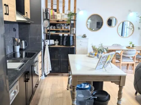 Svijetla kuhinja sa kuhinjskim ostrvom i trpezarijom u pozadini. - image 3