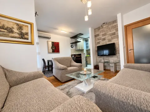Spacious living room with a sofa set, coffee table, and a view of the kitchen in the background. - image 4