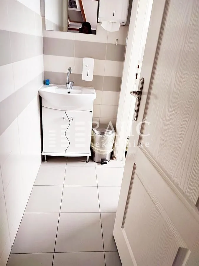 Small bathroom with a sink and white tiles.