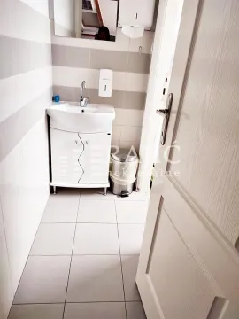 Small bathroom with a sink and white tiles. - image 7