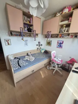 Children's bedroom with a bed, desk, and wall-mounted cabinets. - image 12