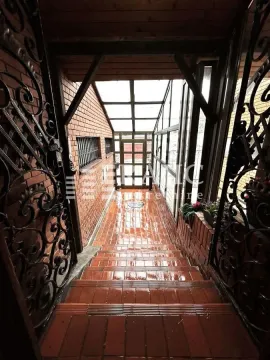 Covered staircase with a glass roof and metal railings leading towards the entrance. - image 3
