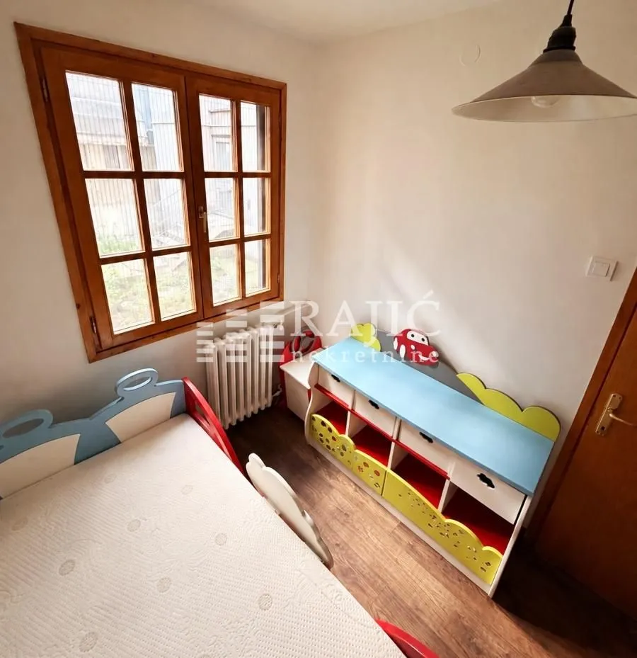 Children's bedroom with a bed and a window.