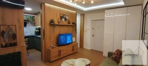 Living room with wooden panels, TV, and a view of the kitchen. - image 6