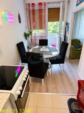 Dining area with a round table and black chairs connected to the kitchen. - image 6