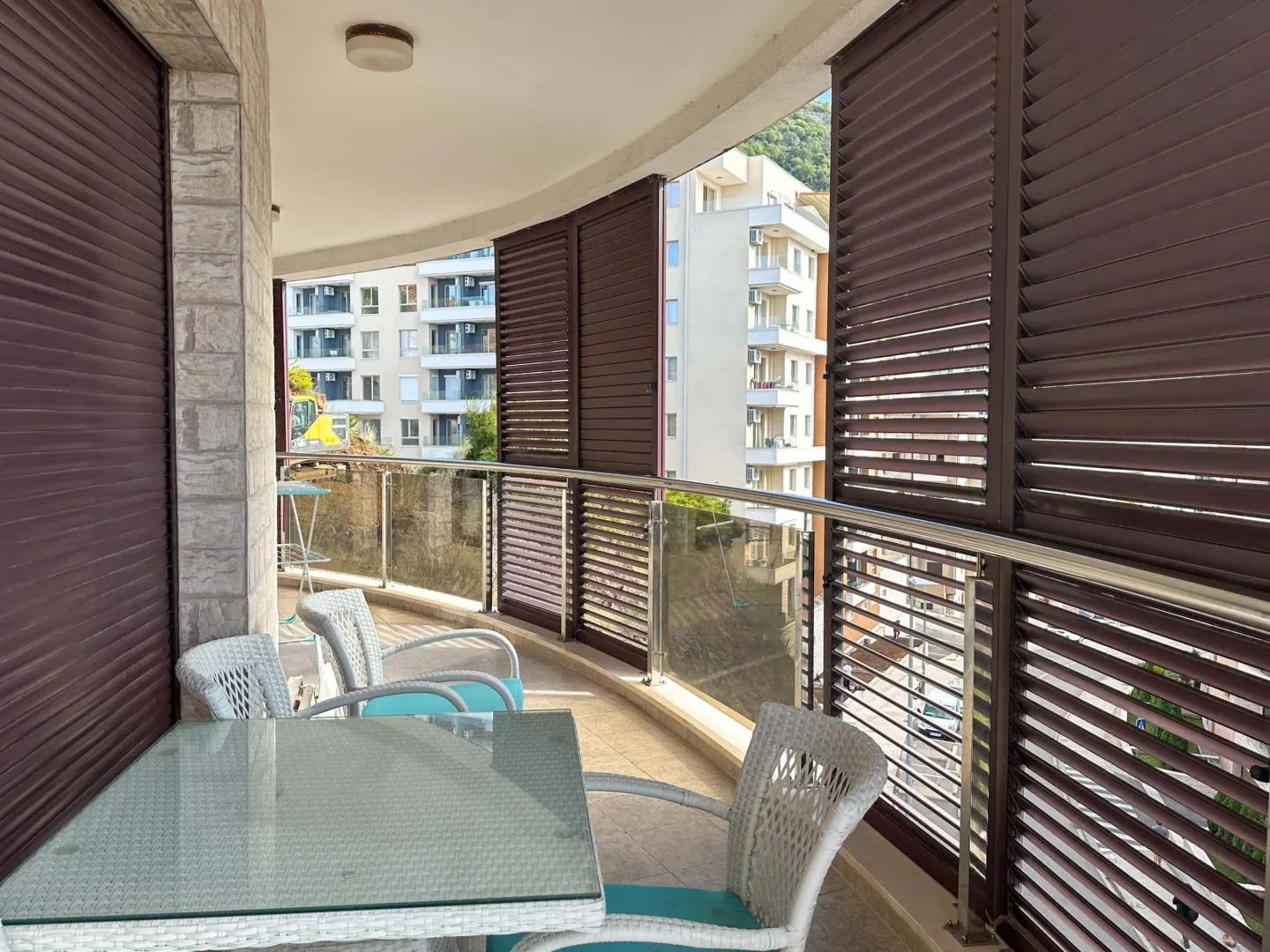 Spacious terrace with outdoor seating and sliding shutters.
