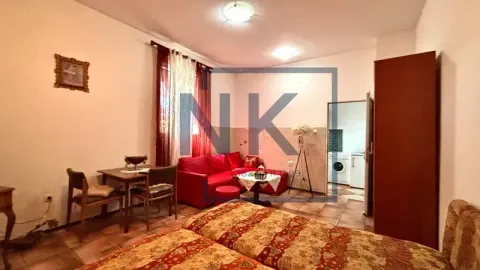 Dnevna soba sa krevetima, crvenom ugaonom garniturom i trpezarijskim stolom. - image 3